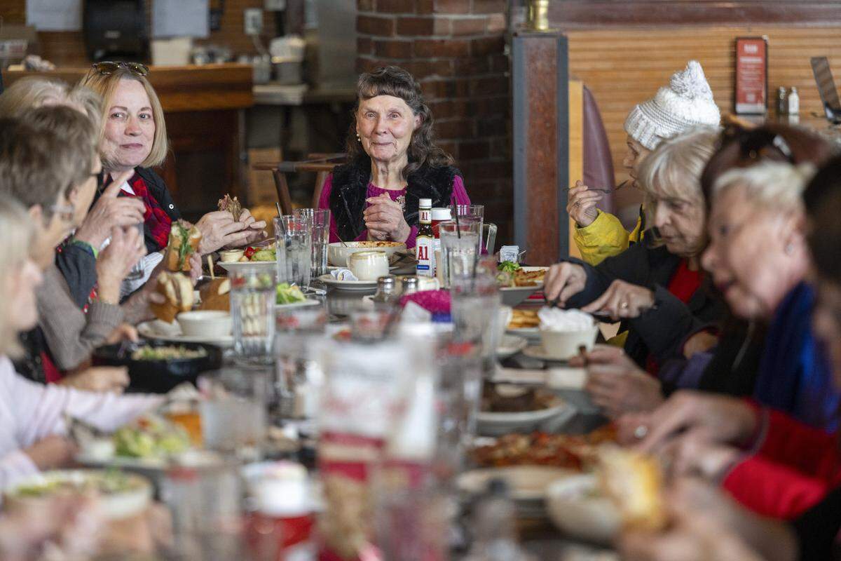 June Craig, center, sits at the head of a long table filled with retired members of Bon Marche and Macy's at the Ram Restaurant on Thursday, Feb. 19, 2026, in Tacoma, Wash. Craig began organizing monthly lunches with fellow former department store workers after her retirement thirty years ago.
