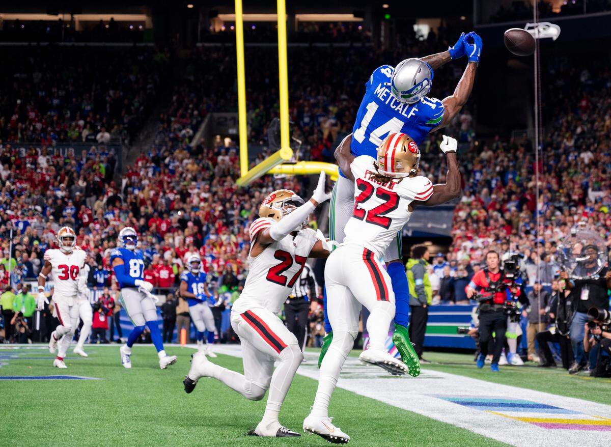 The ball sails past Seattle Seahawks wide receiver DK Metcalf (14) as he goes up under double coverage from San Francisco 49ers cornerback Isaac Yiadom (22) and safety Ji’Ayir Brown (27) during the fourth quarter of the game at Lumen Field, on Thursday, Oct. 10, 2024, in Seattle, Wash.