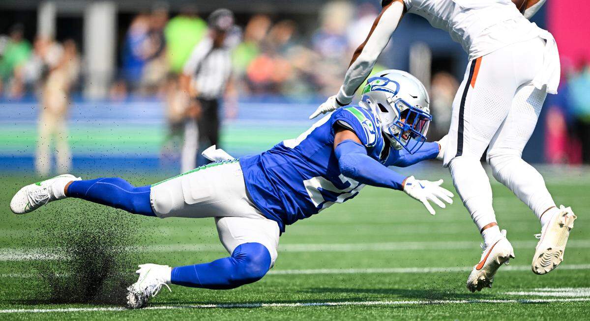 Seattle Seahawks safety Julian Love (20) gives at the shoelaces of Denver Broncos wide receiver Devaughn Vele (17) during the first quarter of the game at Lumen Field, on Sunday, Sept. 8, 2024, in Seattle, Wash.