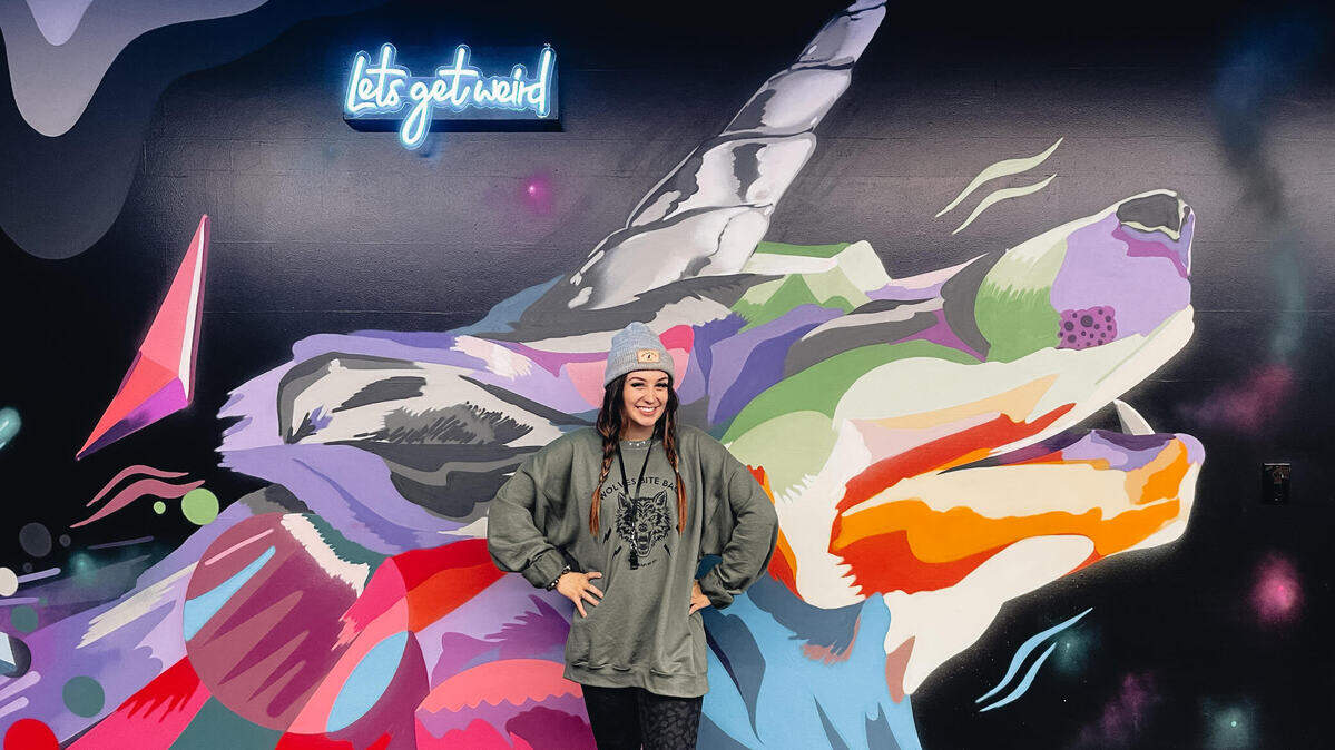 Alexis Drugge, owner of Wolf Heart Fit Co., stands before a mural at her new gym which opened recently at 108 N. Meridian in Puyallup.