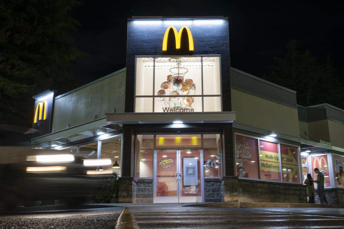 A blown-glass sculpture by artist Dennis Mullen shines above customers moving around the parking lot of the McDonald's on Tacoma Avenue on Friday, Dec. 19, 2025, in Tacoma, Wash.