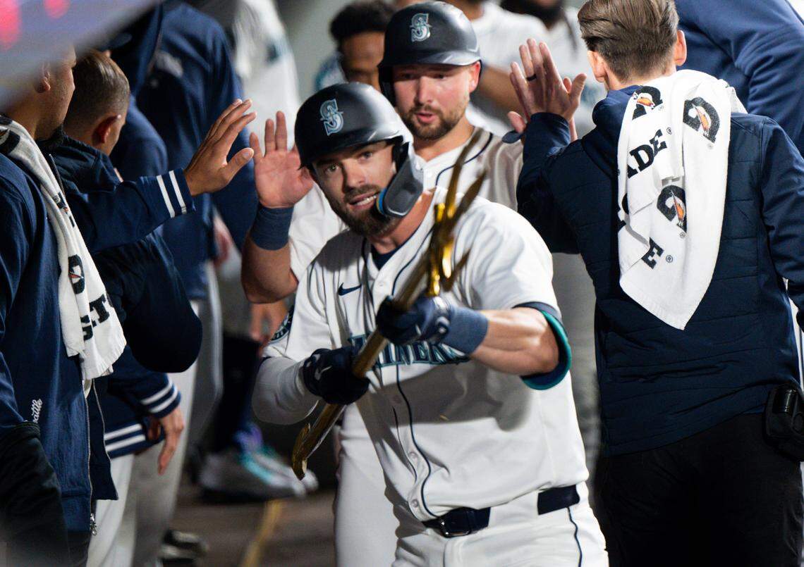 Seattle Mariners left fielder Mitch Haniger (17) holds up the trident in the dugout after hitting a home run against the Boston Red Sox during the fourth inning of the opening day game at T-Mobile Park, on Thursday, March 28, 2024, in Seattle, Wash.