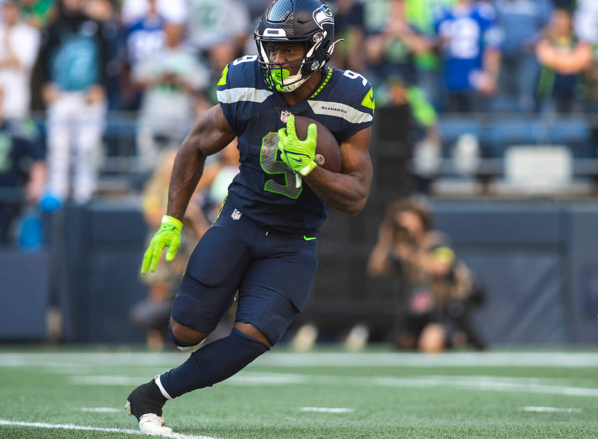 Seattle Seahawks running back Kenneth Walker III (9) runs with the ball after Seattle Seahawks quarterback Geno Smith (7) handed the ball off to him in the third quarter of an NFL game on Sunday, Oct. 16, 2022, at Lumen Field in Seattle.
