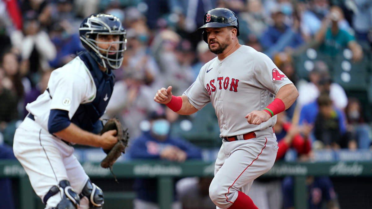 Boston Red Sox’s Kyle Schwarber scores as Seattle Mariners catcher Tom Murphy looks to the infield during the 10th inning of a baseball game Wednesday, Sept. 15, 2021, in Seattle. (AP Photo/Elaine Thompson)