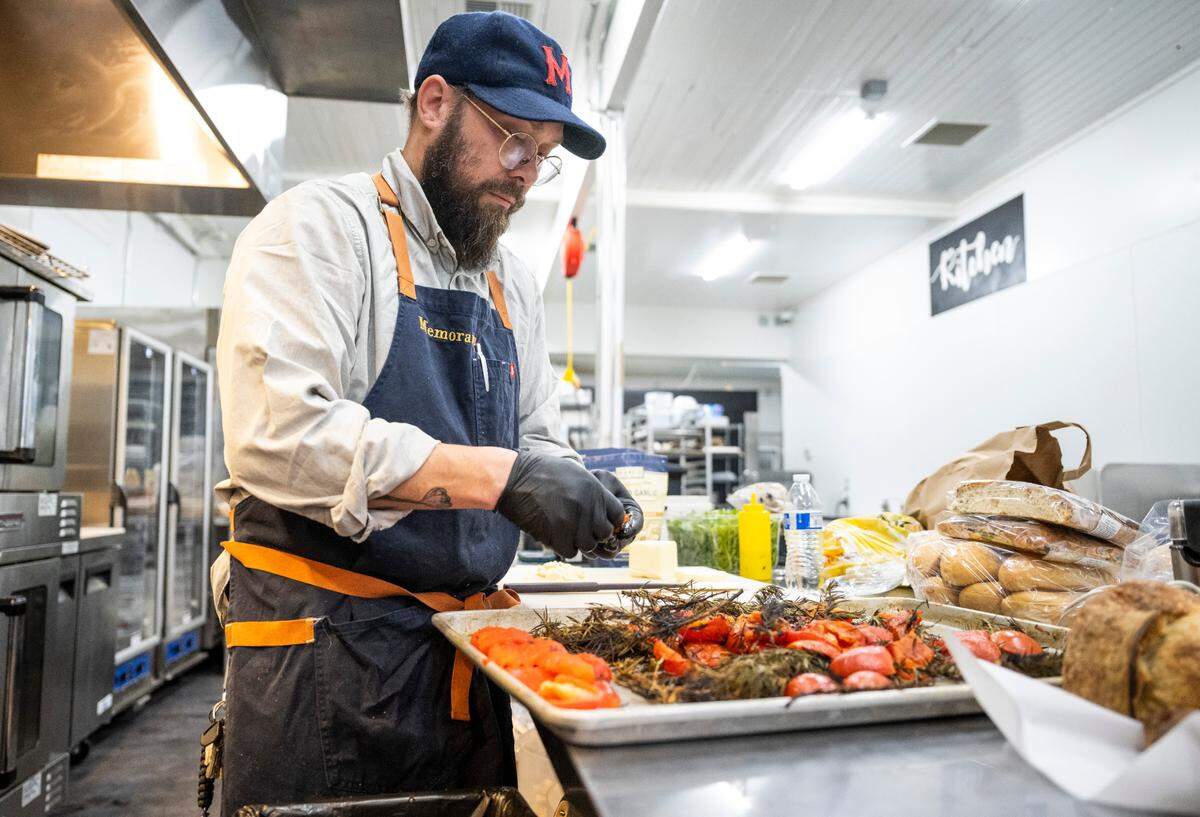 Micah Tucker peels freshly grilled tomatoes for smoked rosemary tomato soup on Nov. 17, 2022. He honed his approach to cooking at Pacific Grill, where soup was one of his specialties.