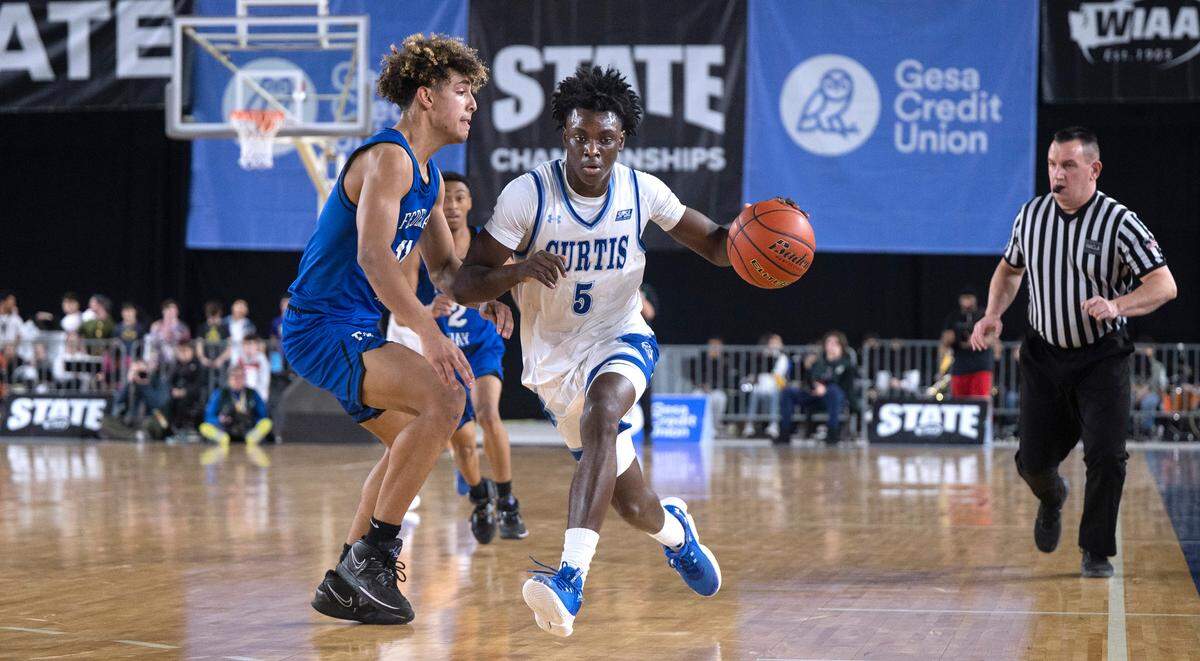 Curtis’ Zoom Diallo pushes the ball up court against Federal Way defender Isaiah Afework during their state semifinal game at the WIAA state basketball tournament in the Tacoma Dome in Tacoma, Washington, on Friday, March 3, 2023. Curtis won the game, 56-43.