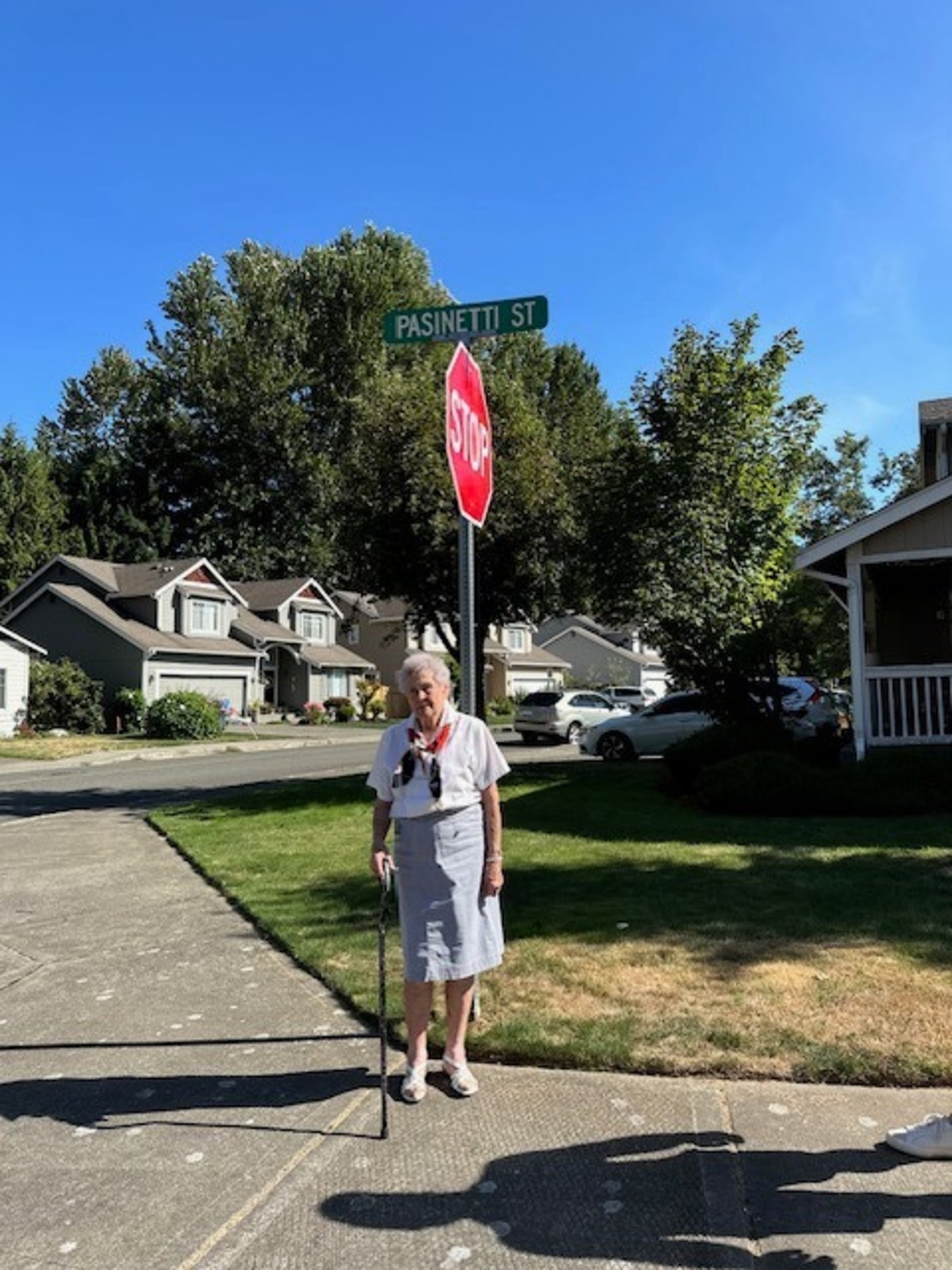 Betty Pasinetti, turning 100 Aug. 20, stands under the street sign bearing her family’s name in Fife.