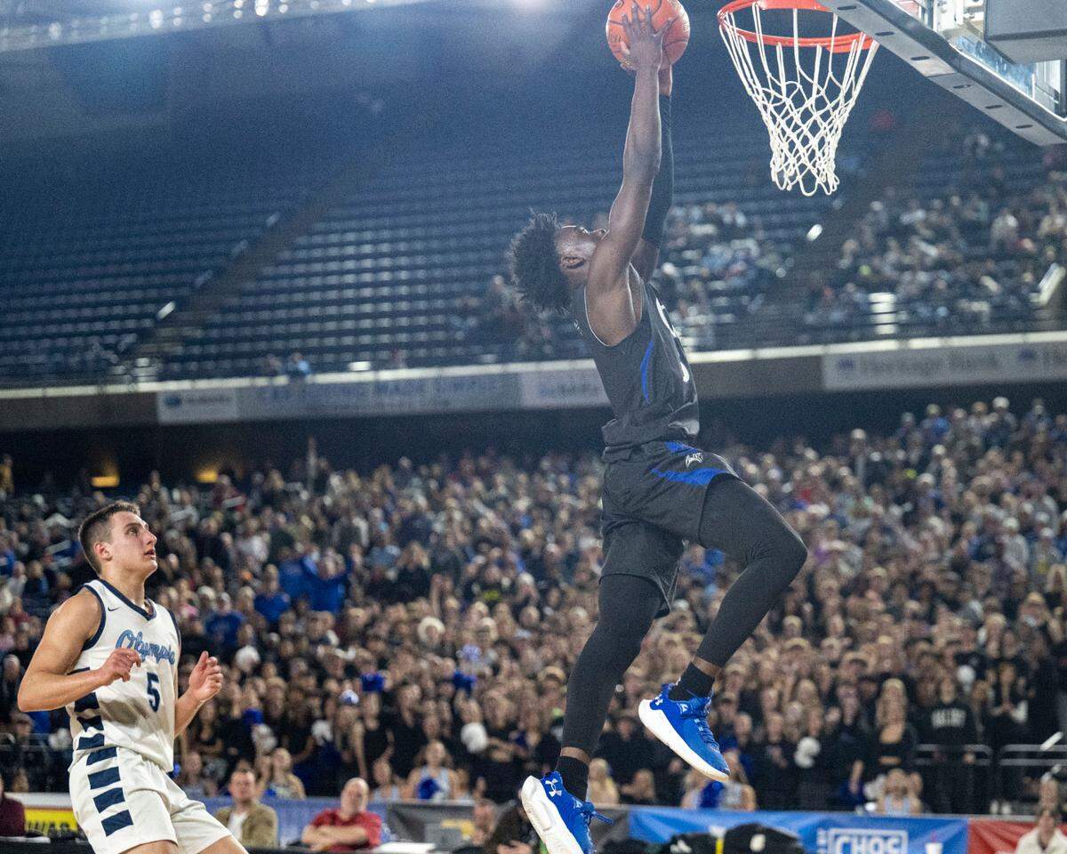 Curtis guard Zoom Diallo (5) dunks the ball on a fast break as Olympia guard Mason Juergens (5) looks on in the third quarter of the Class 4A championship game on Saturday, March 4, 2023, in Tacoma, Wash.