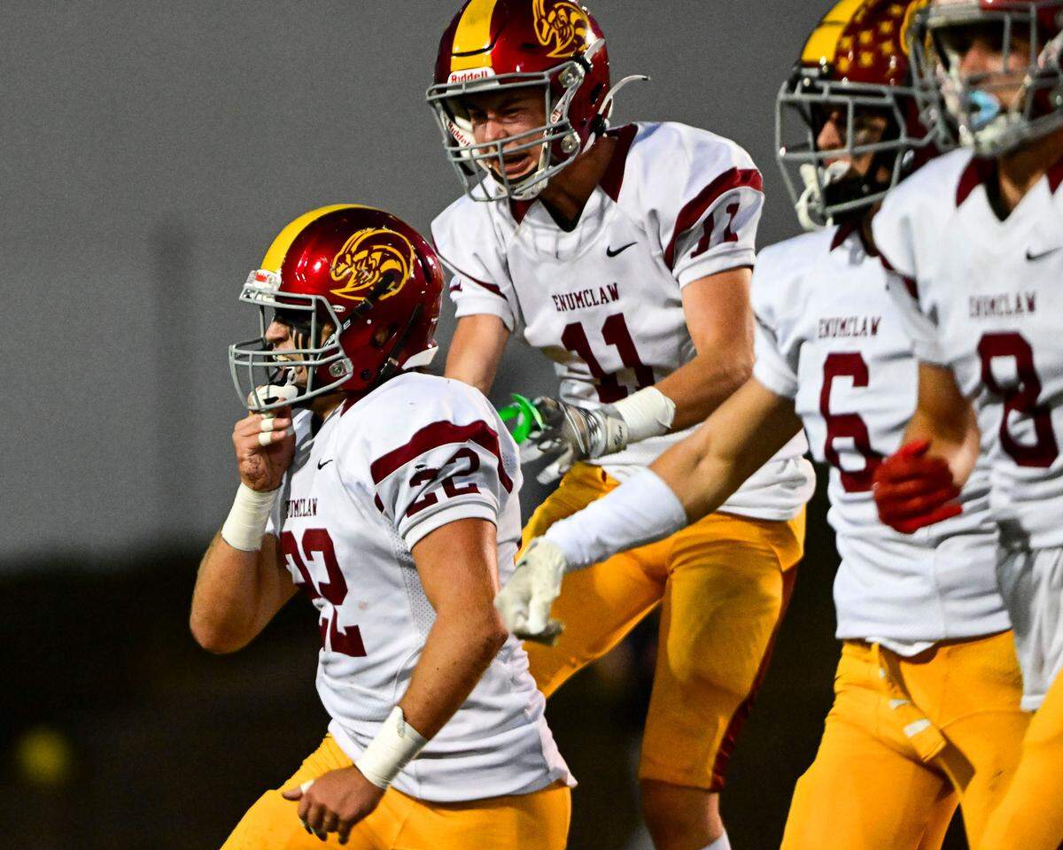 Enumclaw players celebrate after Anthony Mills (22) intercepted a pass by Steilacoom quarterback Drew MacDonald (7) during the second quarter on Friday, Sept. 15, 2023, in Steilacoom, Wash.