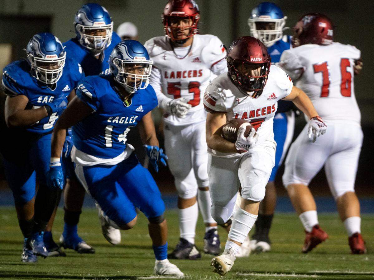 Kennedy Catholic’s Indy Jones rushes through the middle past Federal way’s Keshawn Pham-Roberts during the third quarter of a 4A NPSL game on Friday, Sept. 30, 2022, at Federal Way Memorial Field in Federal Way, Wash.