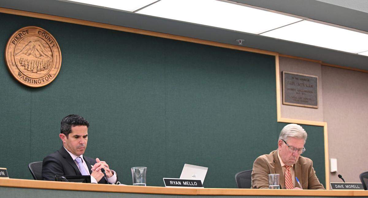Pierce County Council members Ryan Mello (left) and Dave Morrell listen to senior legislative assistant Mike Kruger during a Pierce County Council meeting, Tuesday, July 25, 2023, in Tacoma.