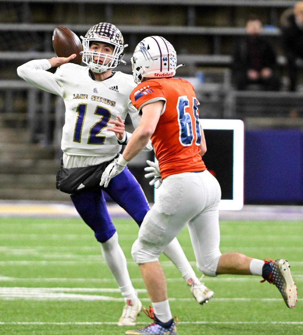 Lake Stevens’ Kolton Matson (12) passes the ball under pressure from Graham-Kapowsin’s Jonathan Haas (66) during the first half of the 4A state championship game at Husky Field, Saturday, Dec. 2, 2023, in Seattle, Wash.