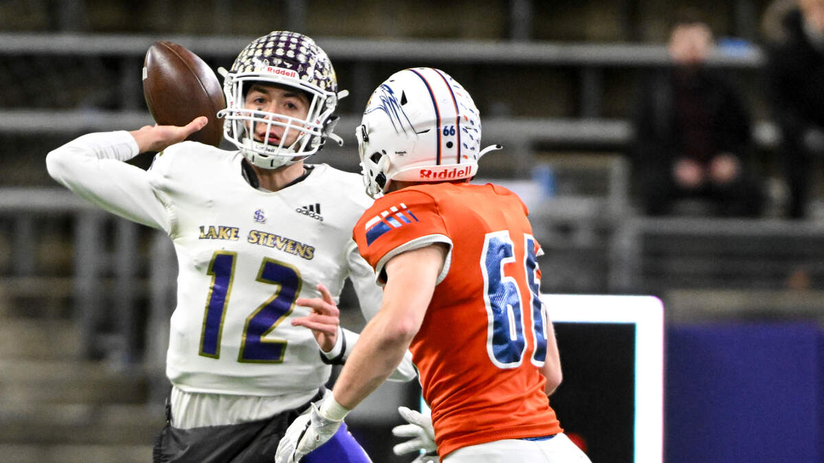 Lake Stevens’ Kolton Matson (12) passes the ball under pressure from Graham-Kapowsin’s Jonathan Haas (66) during the first half of the 4A state championship game at Husky Field, Saturday, Dec. 2, 2023, in Seattle, Wash.