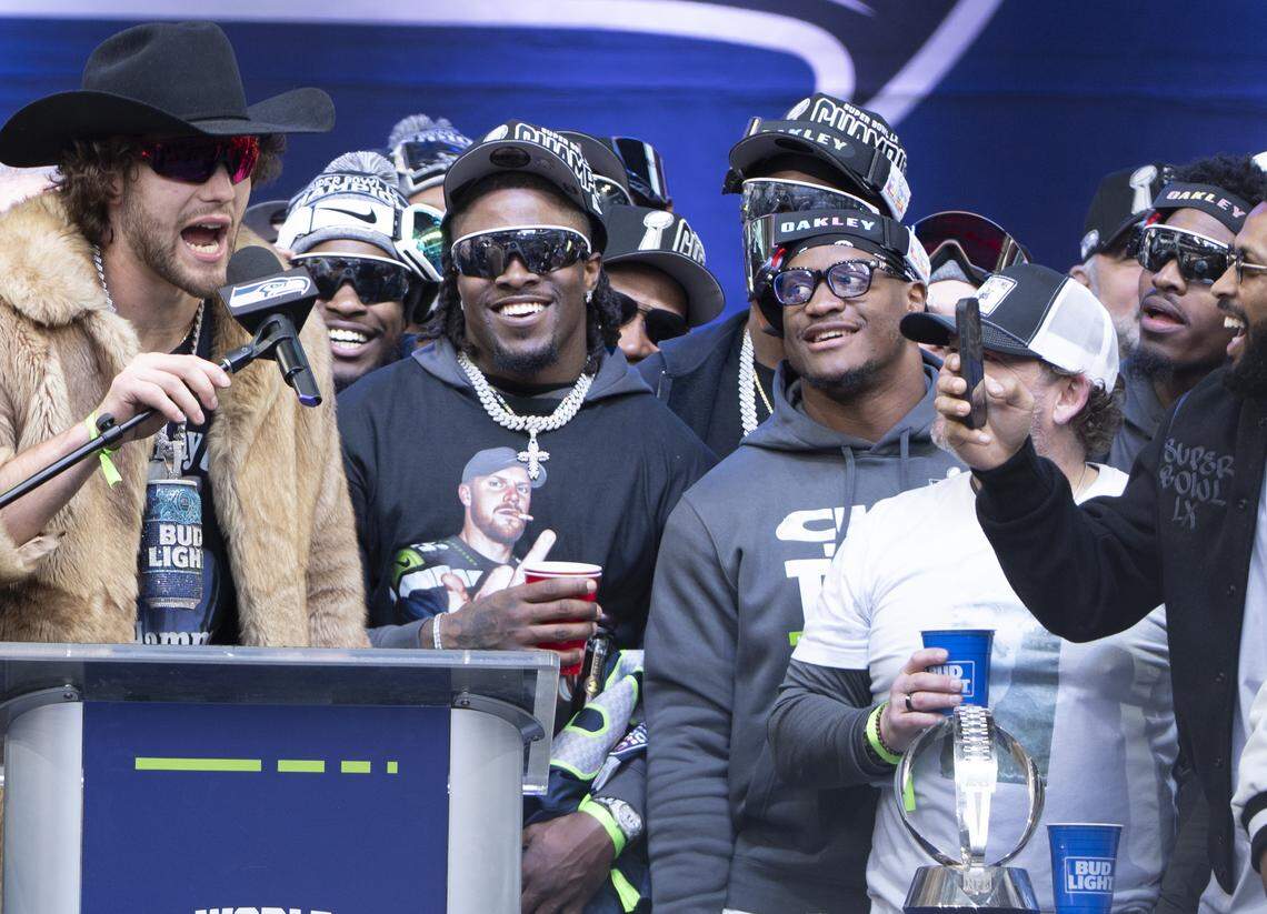 Seattle Seahawks running back Kenneth Walker III, center right with OAKLEY across his forehead, listens to tight end AJ Barner speak from the stage during the team’s Super Bowl trophy celebration event at Lumen Field on Wednesday, Feb. 11, 2026, in Seattle.