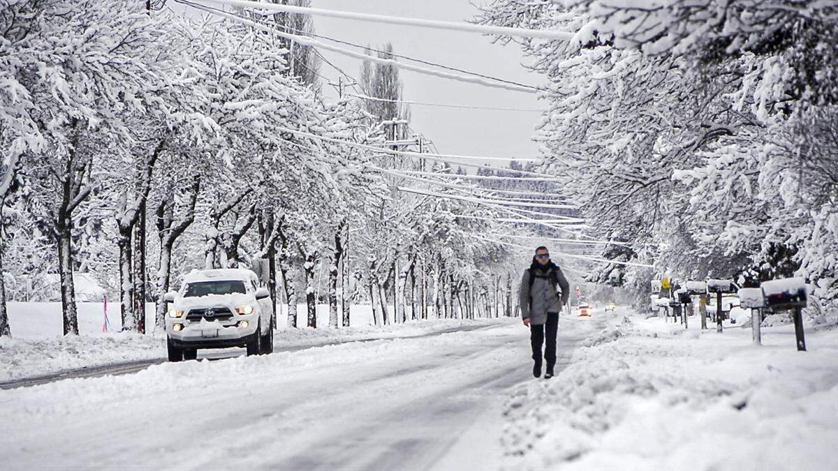 Benjamin O’Brien avoids the deep snow on the sidewalk as he walks along West Pioneer to work in Puyallup, February 9, 2019.