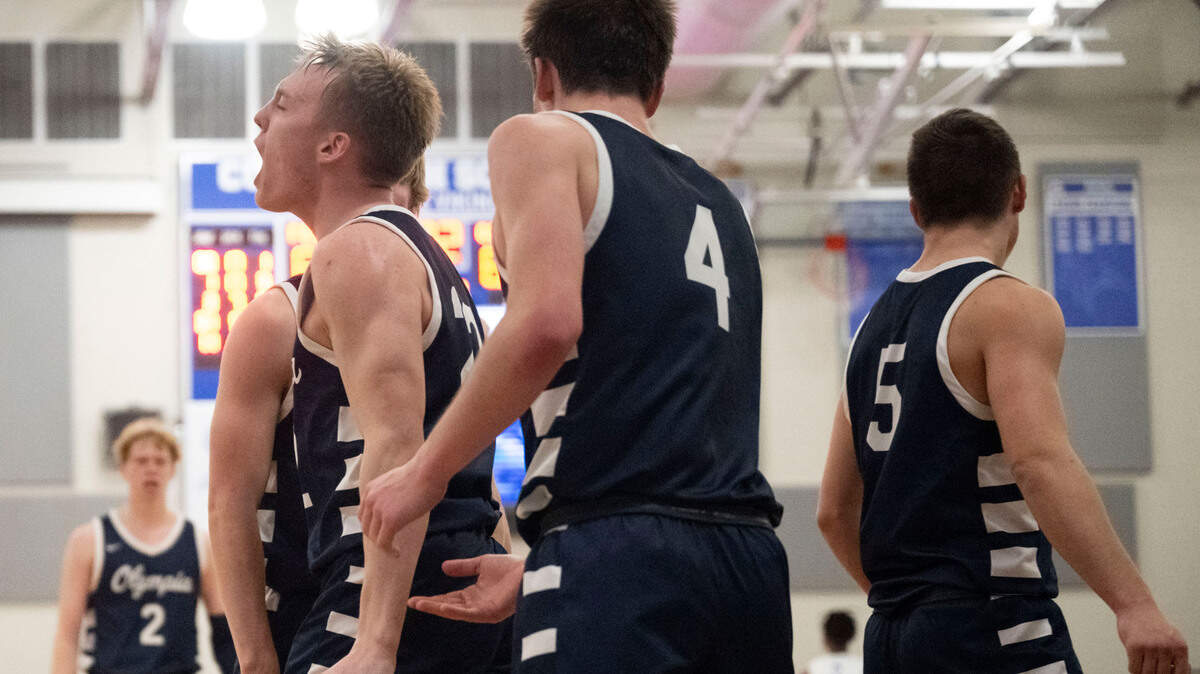 After grabbing an offensive rebound, Olympia guard Parker Gerrits (22) celebrates after making a put back jumper while being fouled during the fourth quarter of a District 3/4 semifinal game against Federal Way on Thursday, Feb. 16, 2023, at Curtis High School in University Place, Wash.