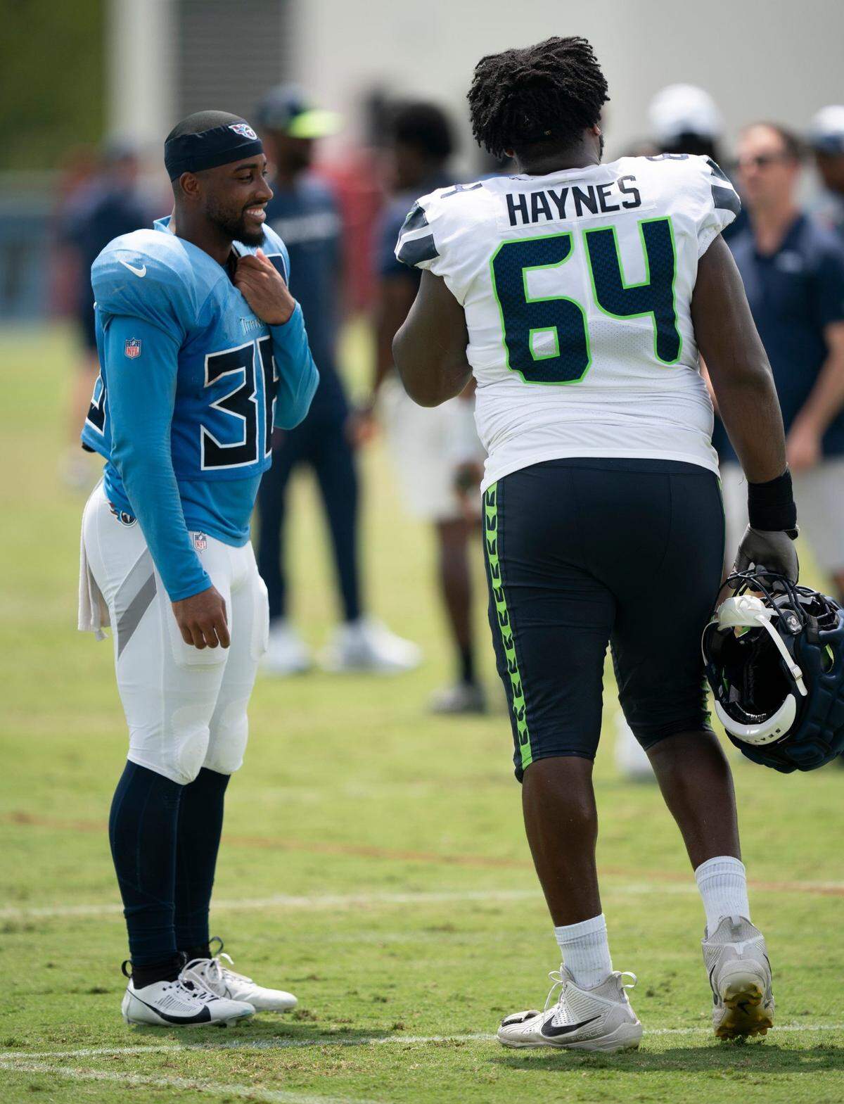 Tennessee Titans running back Julius Chestnut (36) and Seattle Seahawks guard Christian Haynes (64) talk after practice at Ascension Saint Thomas Sports Park in Nashville, Tenn., Wednesday, Aug. 14 2024. This is the first day of the Titans joint practice with the Seattle Seahawks.