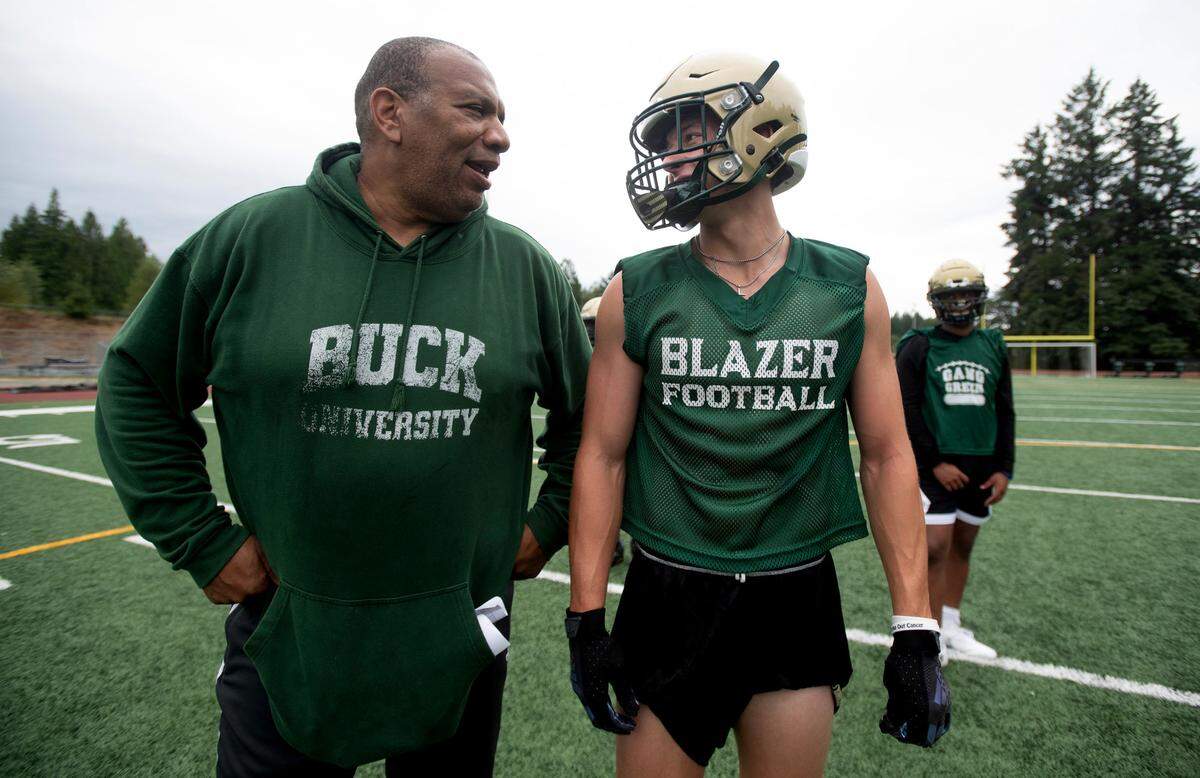 Timberline head coach James Jones chats with wide receiver Jake Nadeau during a break between drills at preseason football practice at Timberline High School in Lacey, Washington, on Thursday, Aug. 22, 2024.