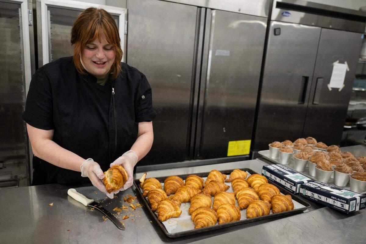 Keely Miguel-Silva is the mastermind behind the flavor combinations, according to her husband. She readies croissants for frangipane filling on May 9, with a tray of just-baked cruffins next to them on the prep table.