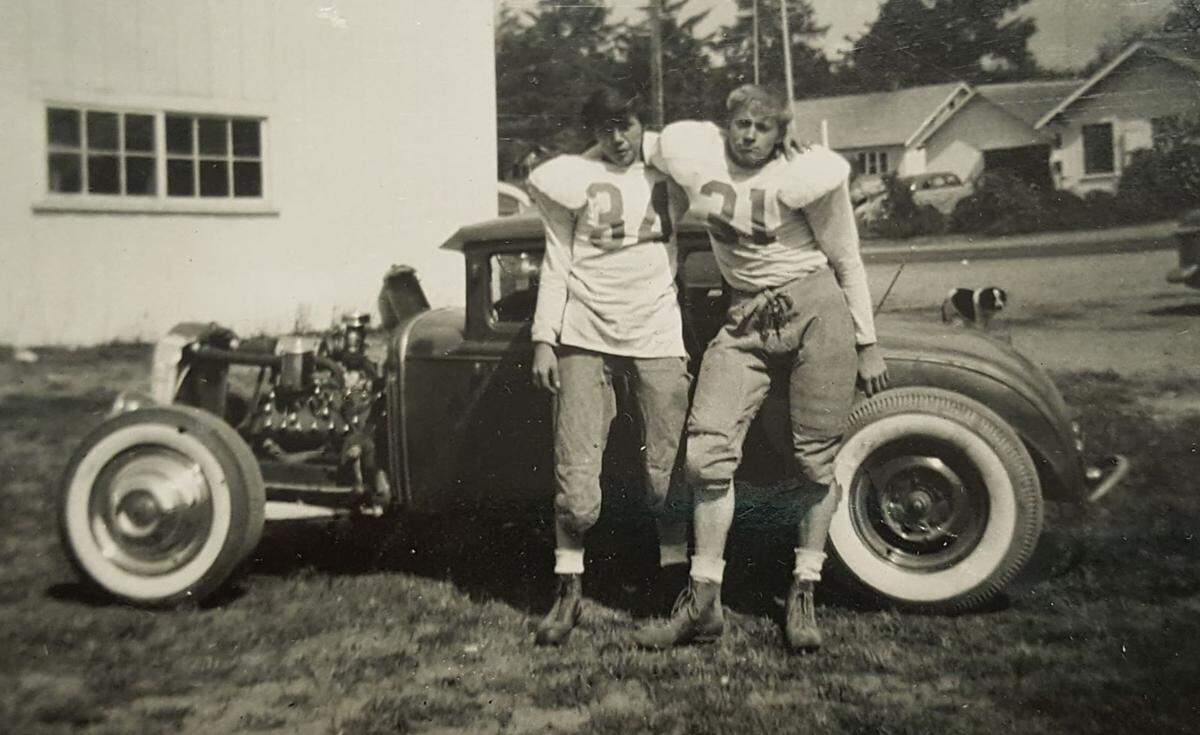 Eugene Landry, left, and a friend pose in their football uniforms in front of Landry’s hot rod circa 1954.