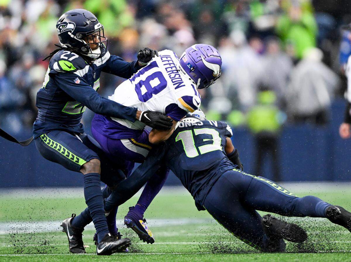 Minnesota Vikings wide receiver Justin Jefferson (18) is tackled by Seattle Seahawks linebacker Ernest Jones IV (13) and cornerback Riq Woolen (27) during the second quarter of the game at Lumen Field, on Sunday, Dec. 22, 2024, in Seattle, Wash.