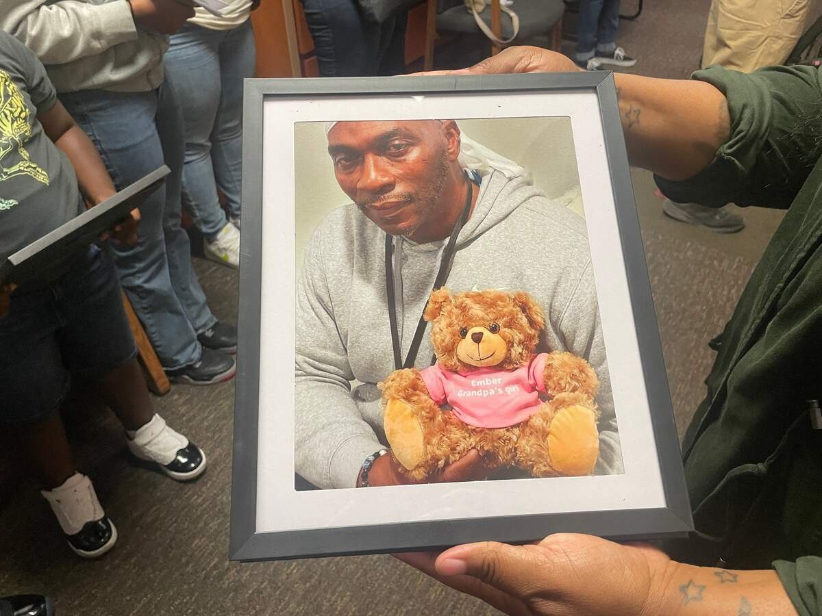 Riquaisha Braxton holds a photograph of her father, Ricktor Murphy, pictured in October 2023 with a teddy bear with his granddaughter’s name. Braxton was in Pierce County Superior Court on Monday, July 21, 2025 to speak in court before Chase Wilcox, 19, was sentenced to 10 years, six months in prison for fatally shooting Murphy during a petty argument in Tacoma. 