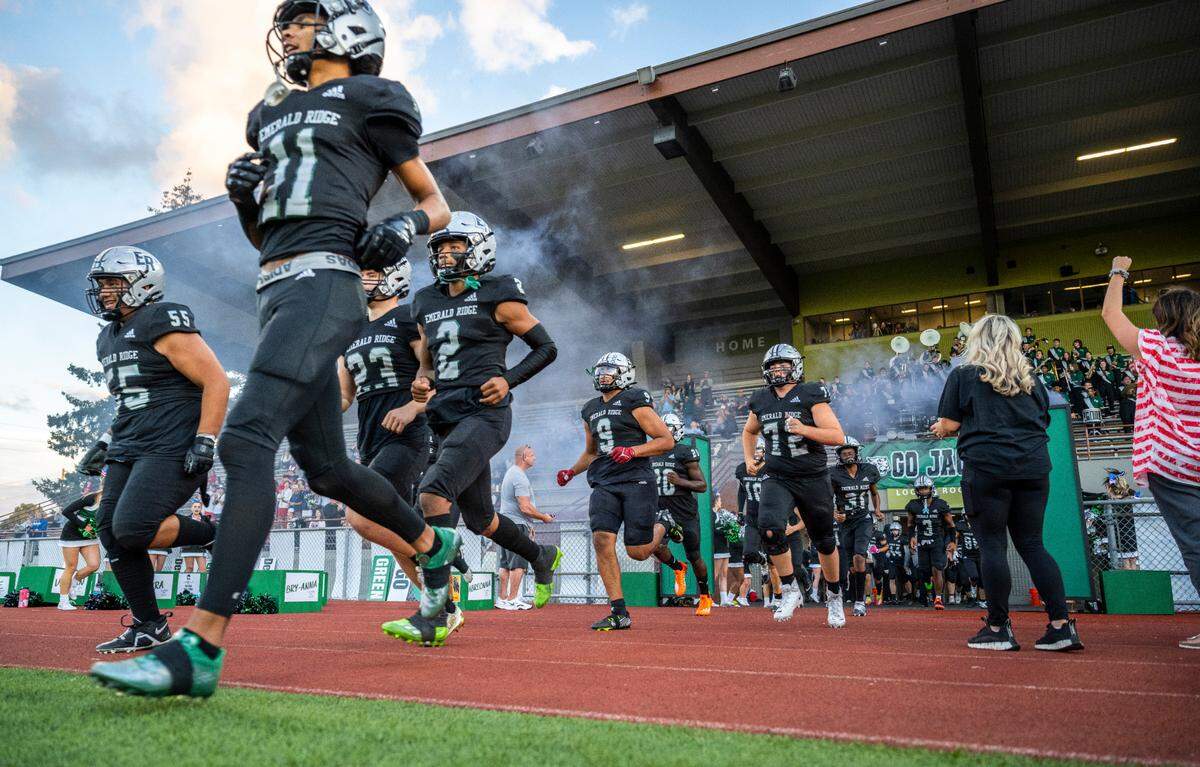 Emerald Ridge varsity football players run onto the field before the start of the game against Curtis at Sparks Stadium in Puyallup, Wash. on Sept. 22, 2022.