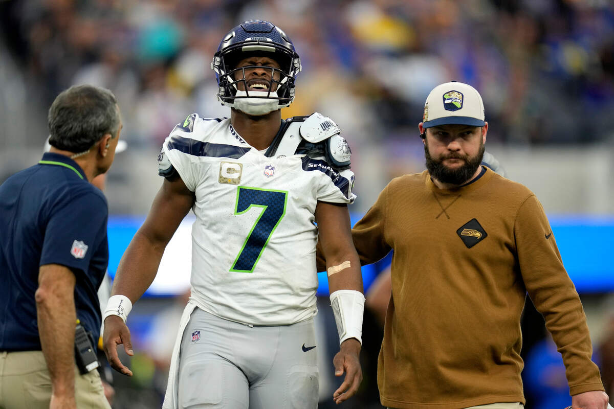 Seattle Seahawks quarterback Geno Smith (7) is helped off the field after an injury during the second half of an NFL football game against the Los Angeles Rams Sunday, Nov. 19, 2023, in Inglewood, Calif. (AP Photo/Ashley Landis)