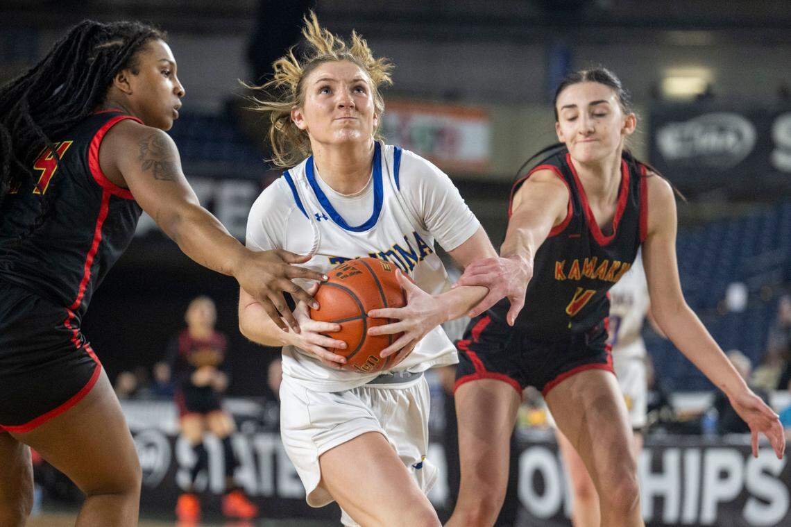 Tahoma guard Hope Hassmann (2) drives to the basket as Kamiakin forward Camia Howard (24) and guard Maddy Rendall (4) during the fourth quarter of the Class 4A 3rd/5th-place game on Saturday, March 4, 2023, in Tacoma, Wash.