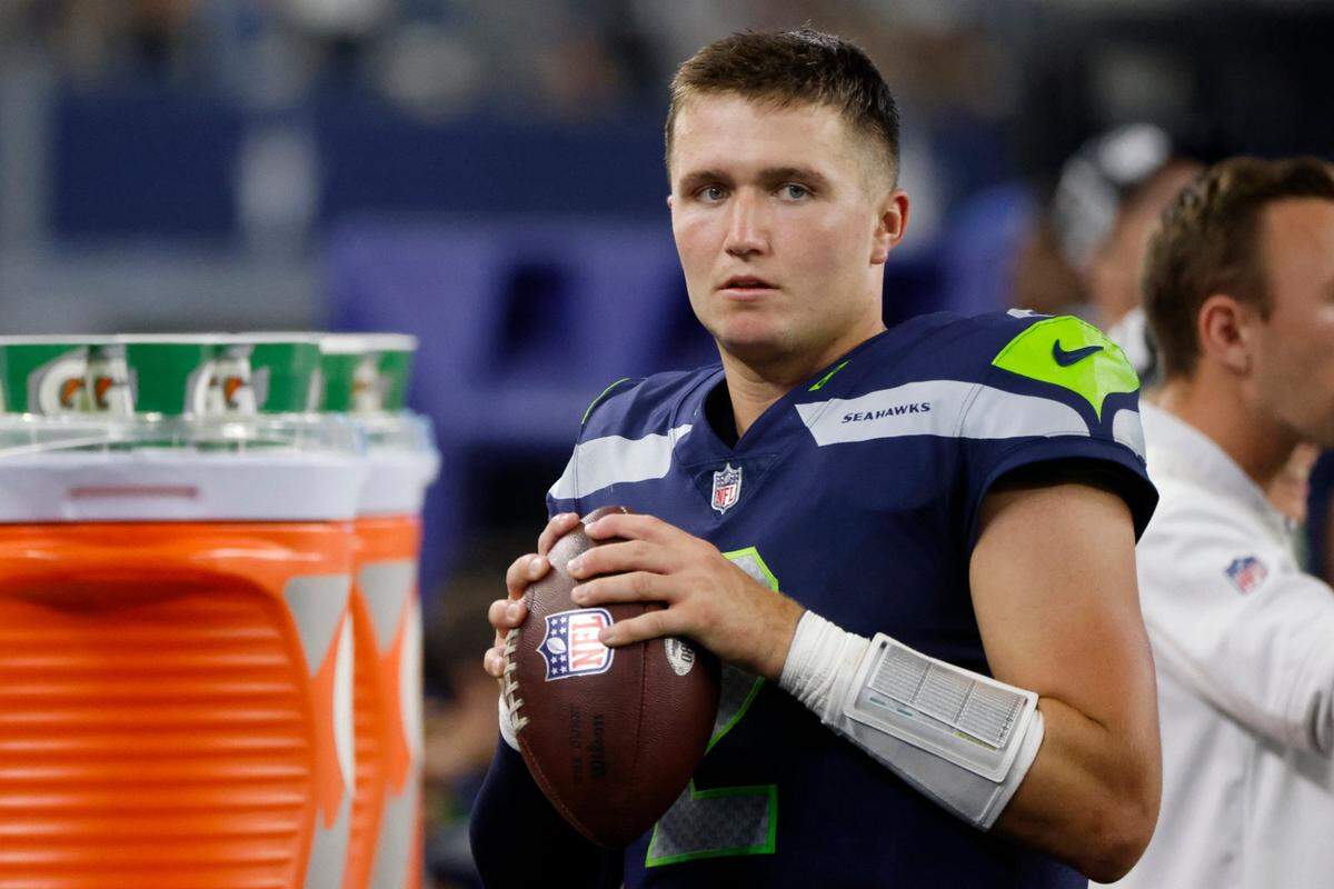 Seattle Seahawks quarterback Drew Lock holds the ball as he stands on the sideline in the second half of a preseason NFL football game against the Dallas Cowboys in Arlington, Texas, Friday, Aug. 26, 2022. (AP Photo/Michael Ainsworth)