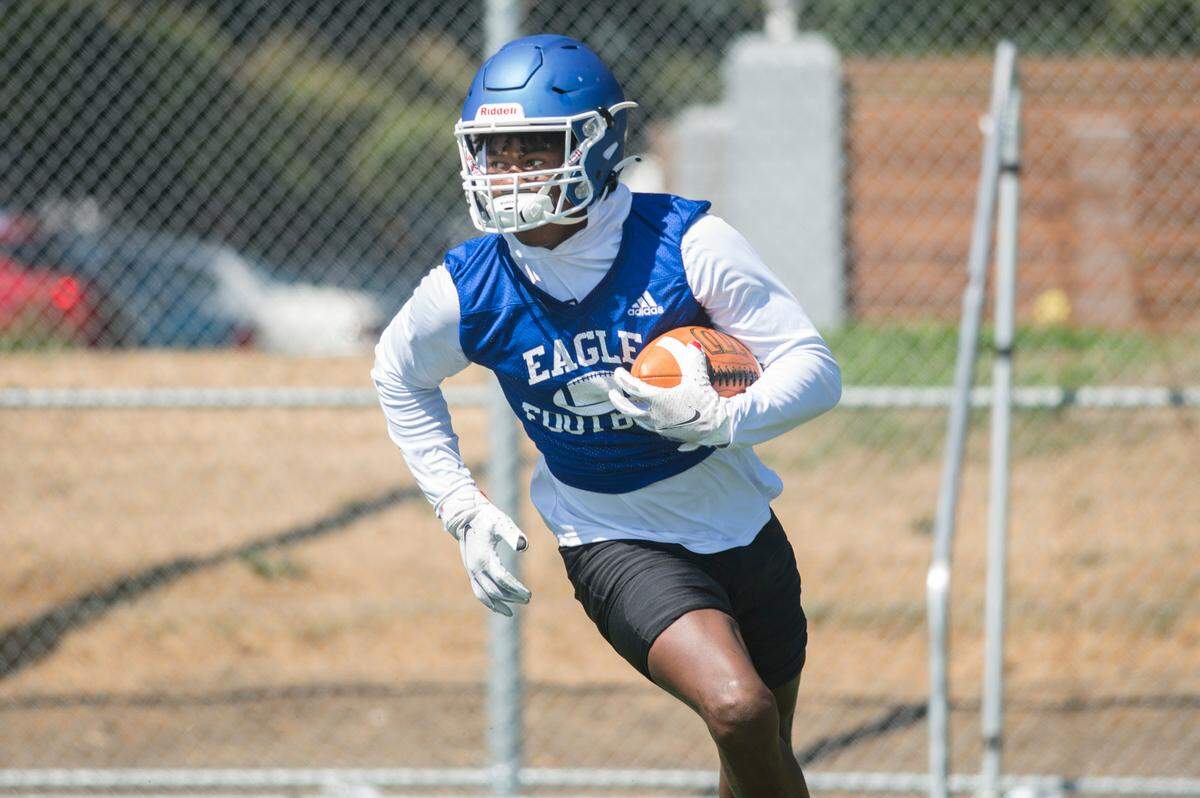 Federal Way High School defensive back Rahshawn Clark runs with the ball during a drill on the first day of practice on Wednesday, Aug. 17, 2022 in Federal Way, Wash.
