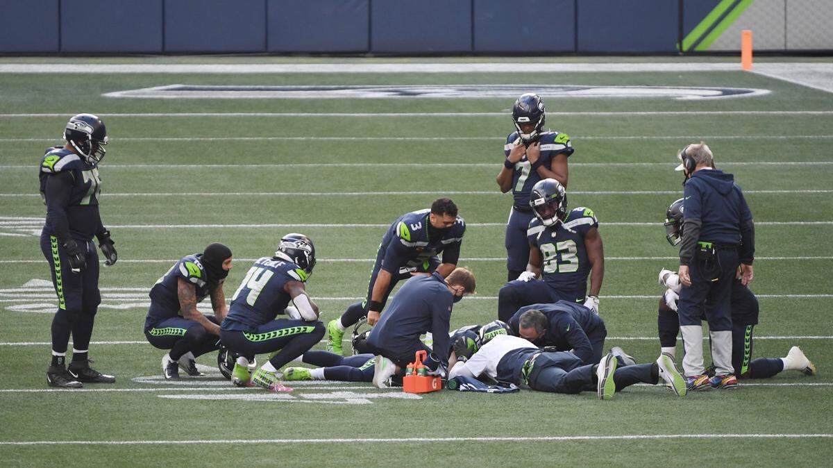 Teammates surround Seattle Seahawks receiver Tyler Lockett (16) on the field after he was injured during a catch in the first quarter of a game against the New York Giants on Sunday, Dec. 6, 2020 at Lumen Field in Seattle, Wash.