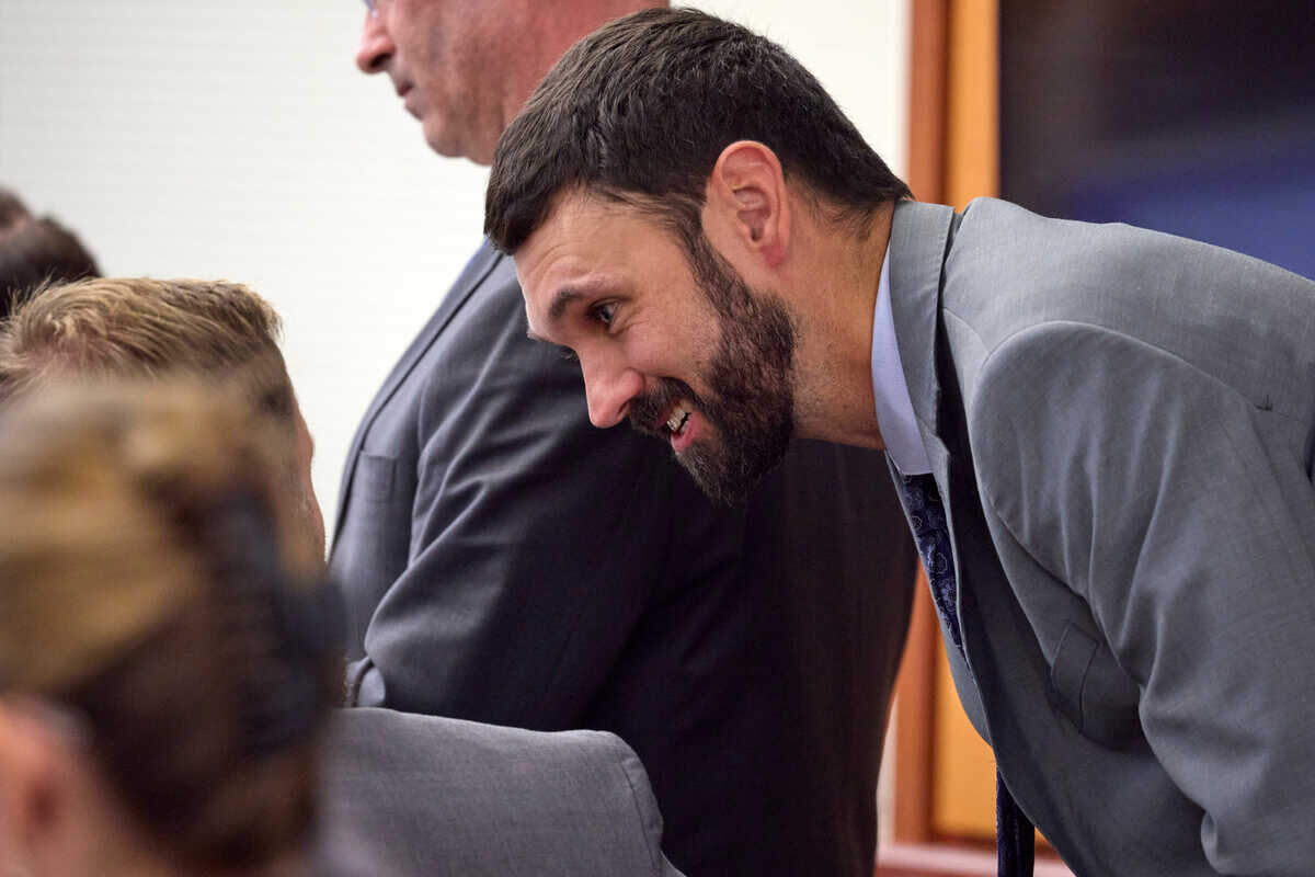 Officer Christopher “Shane” Burbank talks with officer Matthew Collins during the trial of Tacoma Police officers accused in the death of Manny Ellis held at Pierce County Superior Court, Thursday, Oct. 26, 2023, in Tacoma, Wash. Officers Christopher Burbank, Matthew Collins and Timothy Rankine are charged. (John Froschauer/Pool Photo AP)