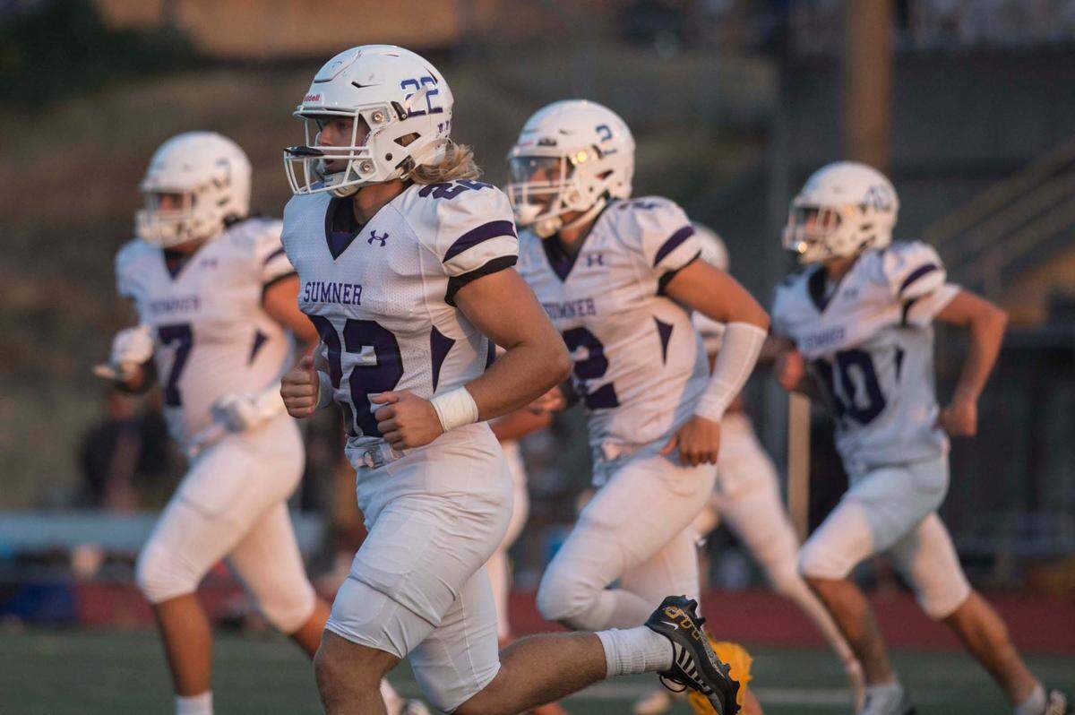 Sumner High School running back Matthew Spurbeck (22) warms up alongside teammates before a football game against Curtis on Friday, Sept. 9, 2022 at Viking Stadium in University Place, Wash.