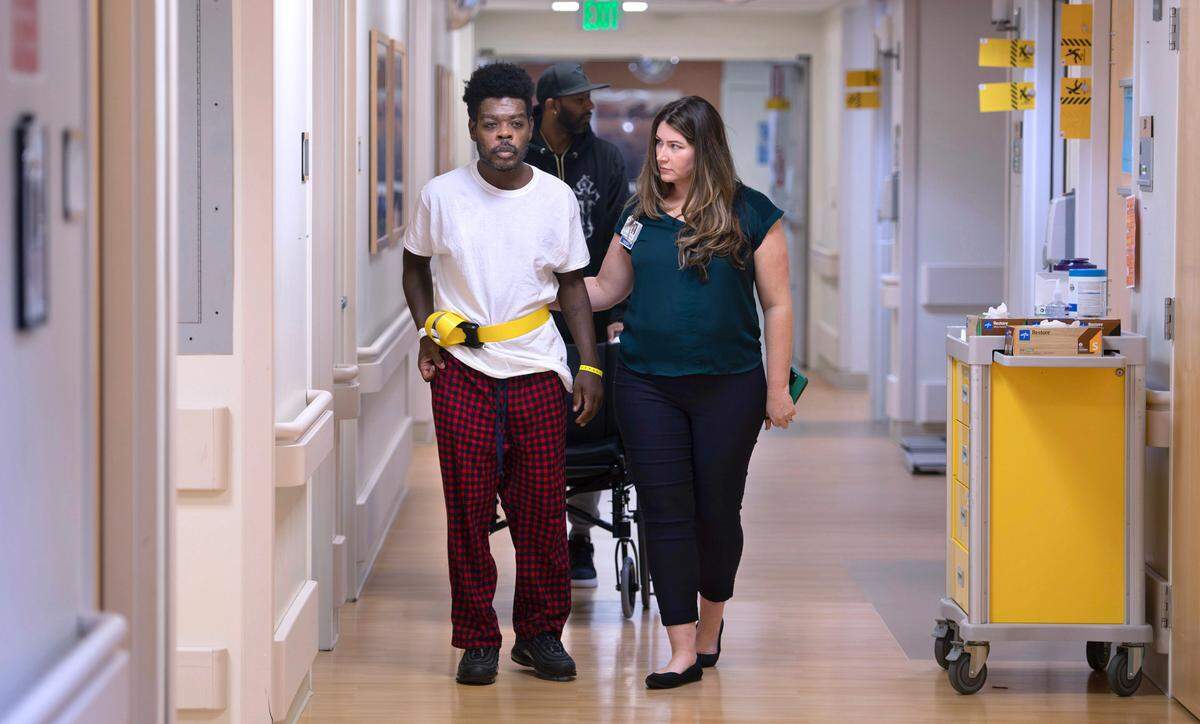Leo Roberson of Graham is supported by therapy manager Cathryn Shaffer as he prepares to return home after a stroke led the 43-year-old security guard to a stay in the Rehabilitation Center at Good Samaritan Hospital in Puyallup, Washington, on Thursday, Dec. 12, 2024.