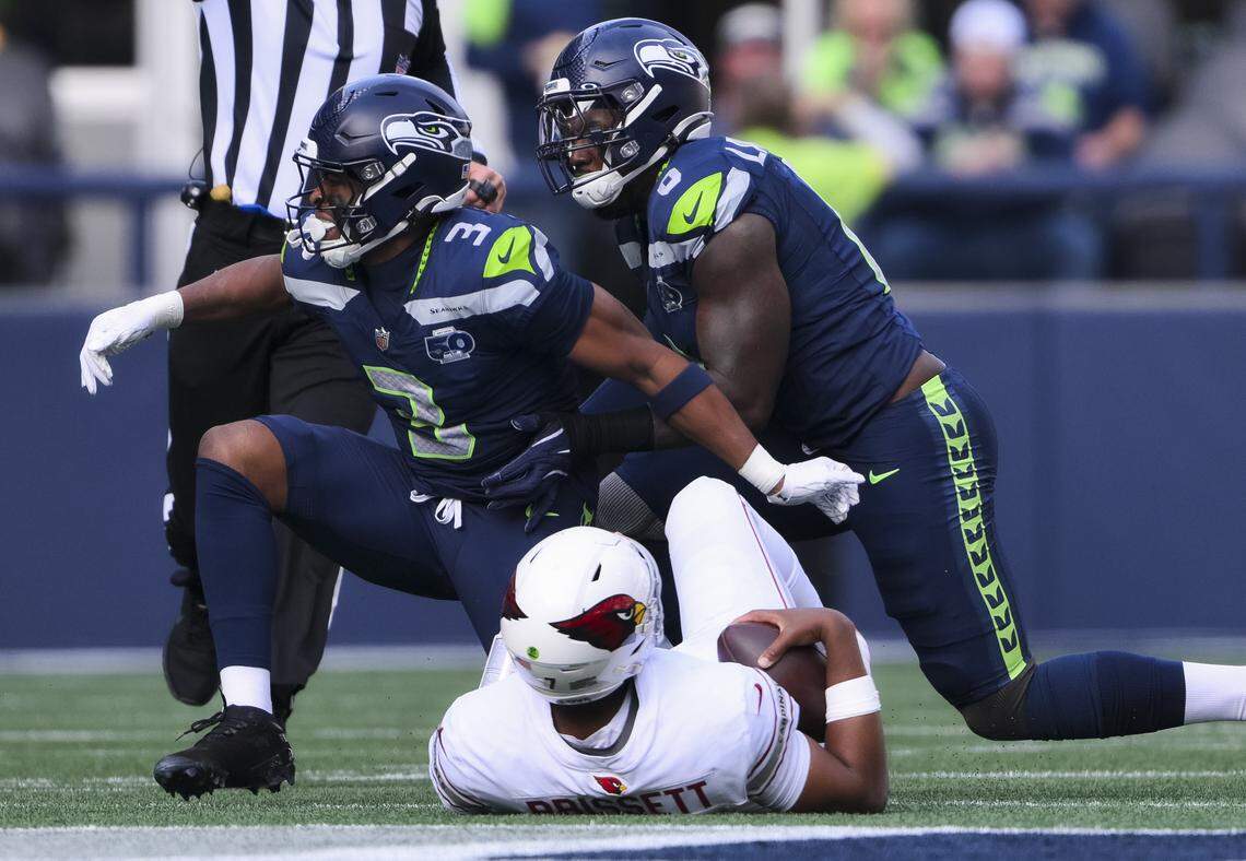 Seattle Seahawks safety Nick Emmanwori (3) and defensive end DeMarcus Lawrence (0) react to a sack against Arizona Cardinals quarterback Jacoby Brissett (7) for a 6-yard loss during the second quarter of the game at Lumen Field, on Sunday, Nov. 9, 2025, in Seattle.