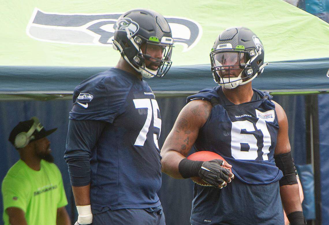 Center Kyle Fuller (61), confers with tackle Greg Eiland on fourth day of Seahawks training camp Saturday, July 31, 2021 at the VMAC in Renton.