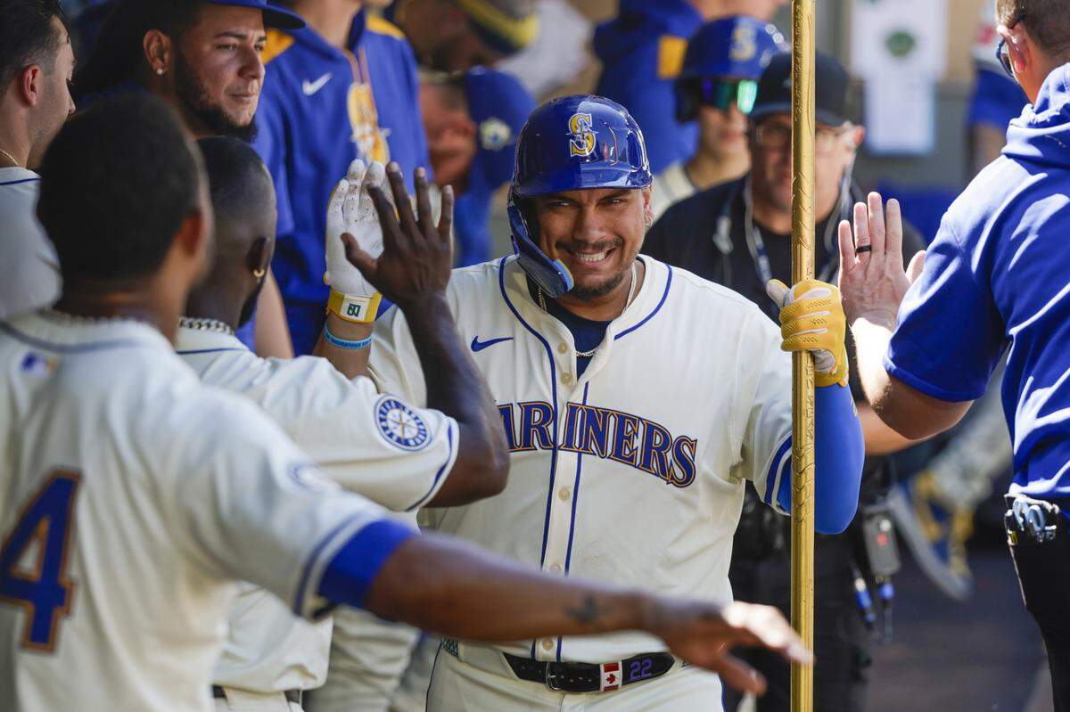 Aug 10, 2025; Seattle, Washington, USA; Seattle Mariners first baseman Josh Naylor (12) celebrates in the dugout after hitting a solo-home run against the Tampa Bay Rays during the seventh inning at T-Mobile Park. Mandatory Credit: Joe Nicholson-Imagn Images