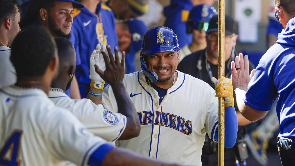 Aug 10, 2025; Seattle, Washington, USA; Seattle Mariners first baseman Josh Naylor (12) celebrates in the dugout after hitting a solo-home run against the Tampa Bay Rays during the seventh inning at T-Mobile Park. Mandatory Credit: Joe Nicholson-Imagn Images