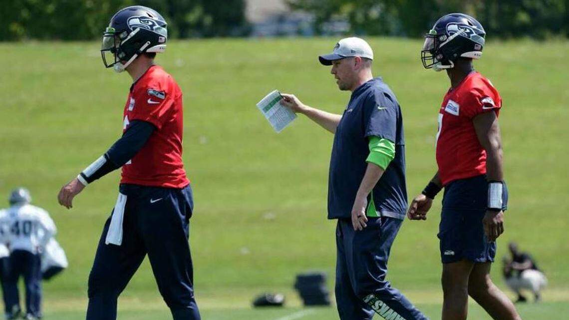 Offensive coordinator and play caller Shane Waldron (center) between quarterbacks Drew Lock (left) and Geno Smith (right) during Seahawks organized team activities (OTAs) practice, May 23, 2022, at team headquarters in Renton.