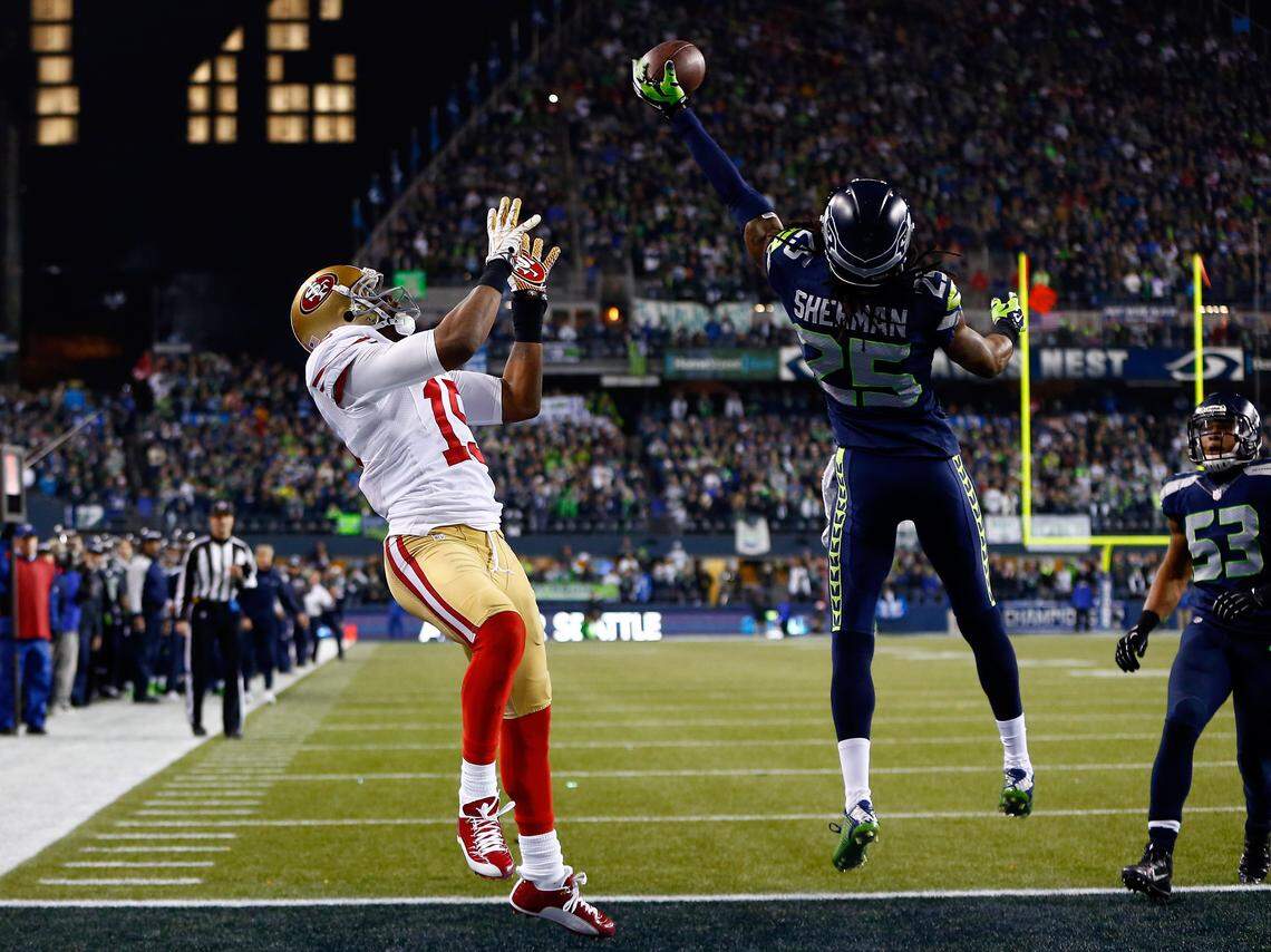 SEATTLE, WA - JANUARY 19: Cornerback Richard Sherman #25 of the Seattle Seahawks tips the ball up in the air as outside linebacker Malcolm Smith #53 catches it to clinch the victory for the Seahawks against the San Francisco 49ers during the 2014 NFC Championship at CenturyLink Field on January 19, 2014 in Seattle, Washington. (Photo by Jonathan Ferrey/Getty Images)