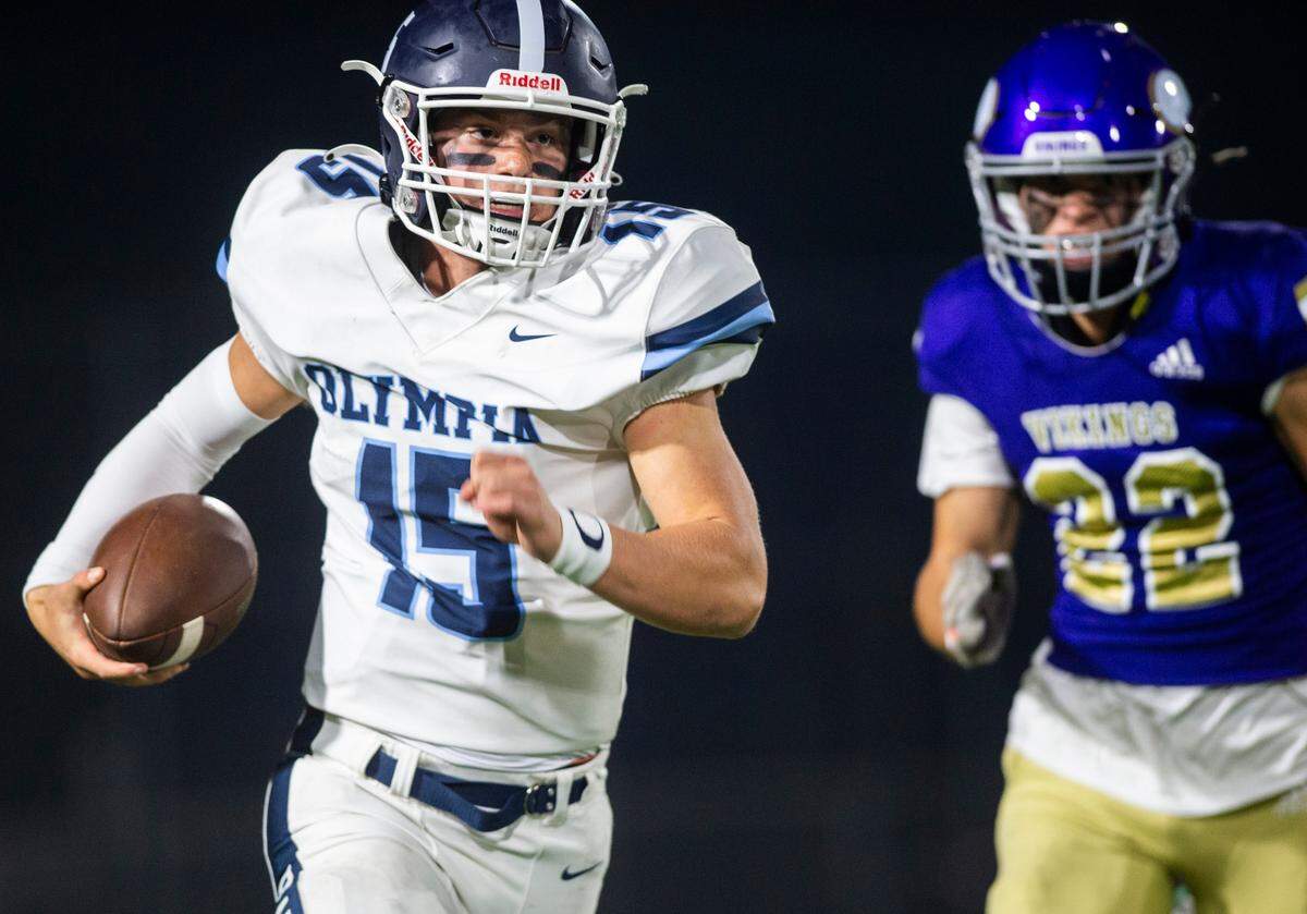 Olympia quarterback Gabe Downing (15) runs down the field with the ball in the third quarter of a game against Puyallup at Sparks Stadium in Puyallup, Wash. on Oct. 6, 2022. Puyallup defeated Olympia 29-24.