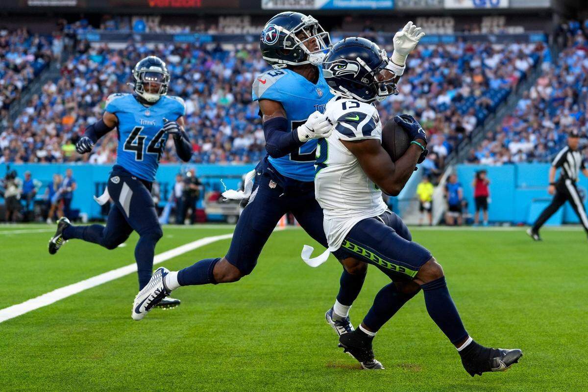 Seattle Seahawks wide receiver Easop Winston Jr. (13) pulls in a touchdown past Tennessee Titans cornerback Tre Avery (23) during the first quarter at Nissan Stadium in Nashville, Tenn., Saturday, Aug. 17, 2024.