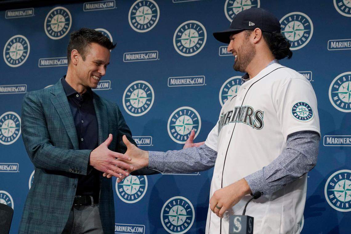 Jerry Dipoto, left, Seattle Mariners President of Baseball Operations, shakes hands with new Seattle Mariners pitcher Robbie Ray, right, Wednesday, Dec. 1, 2021, during a news conference in Seattle. The AL Cy Young Award winner — who previously pitched for the Toronto Blue Jays — signed a five-year contract with the Mariners. (AP Photo/Ted S. Warren)