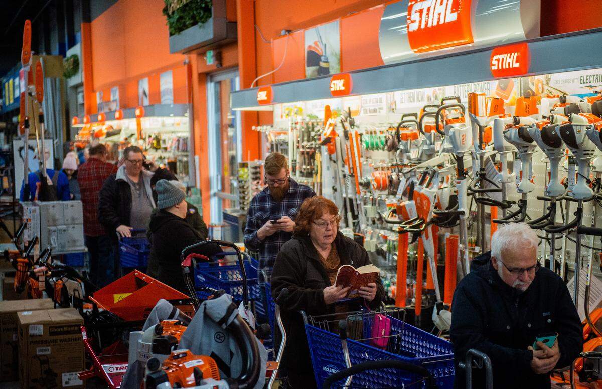 People wait in line for de-icer and snow shovels at McLendon Hardware in Tacoma, Wash., on Friday, Feb. 8, 2019.