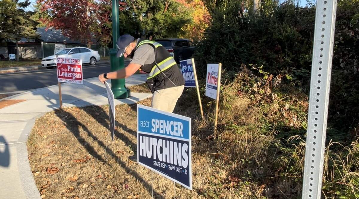 Code enforcers verify permits attached to campaign signs Oct. 13, 2022 in Gig Harbor.