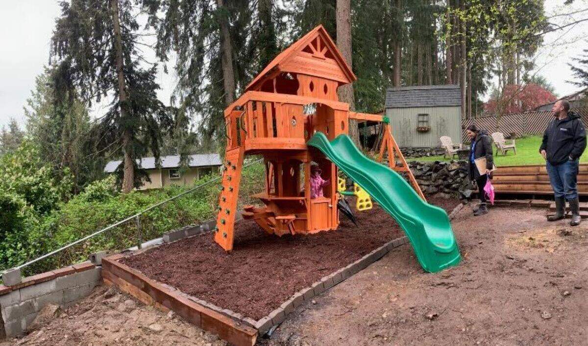 The Gardner family’s new playset comes with two swings, a slide, a rock-climbing wall as well as a covered section with seats on the opposite side.