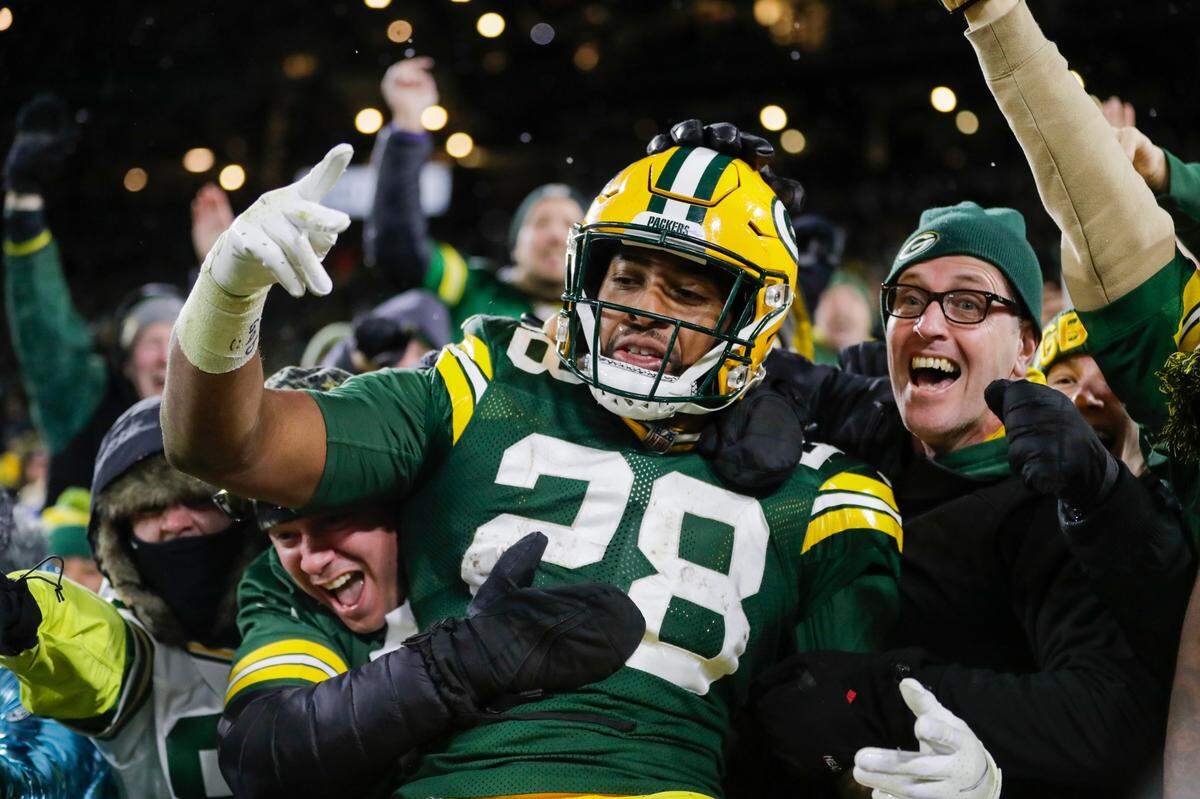 Green Bay Packers’ AJ Dillon celebrates with fans after rushing for a touchdown during the second half of an NFL football game against the Seattle Seahawks Sunday, Nov. 14, 2021, in Green Bay, Wis. (AP Photo/Aaron Gash)