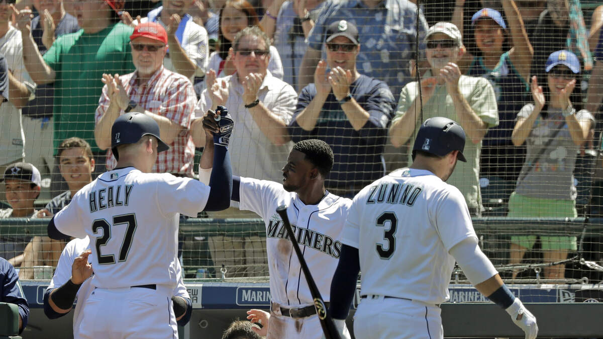 Fans cheer as Seattle Mariners Ryon Healy (27) is greeted by Dee Gordon, center, after Healy hit a solo home run against the San Francisco Giants during the second inning of a baseball game, Wednesday, July 25, 2018, in Seattle. (AP Photo/Ted S. Warren)