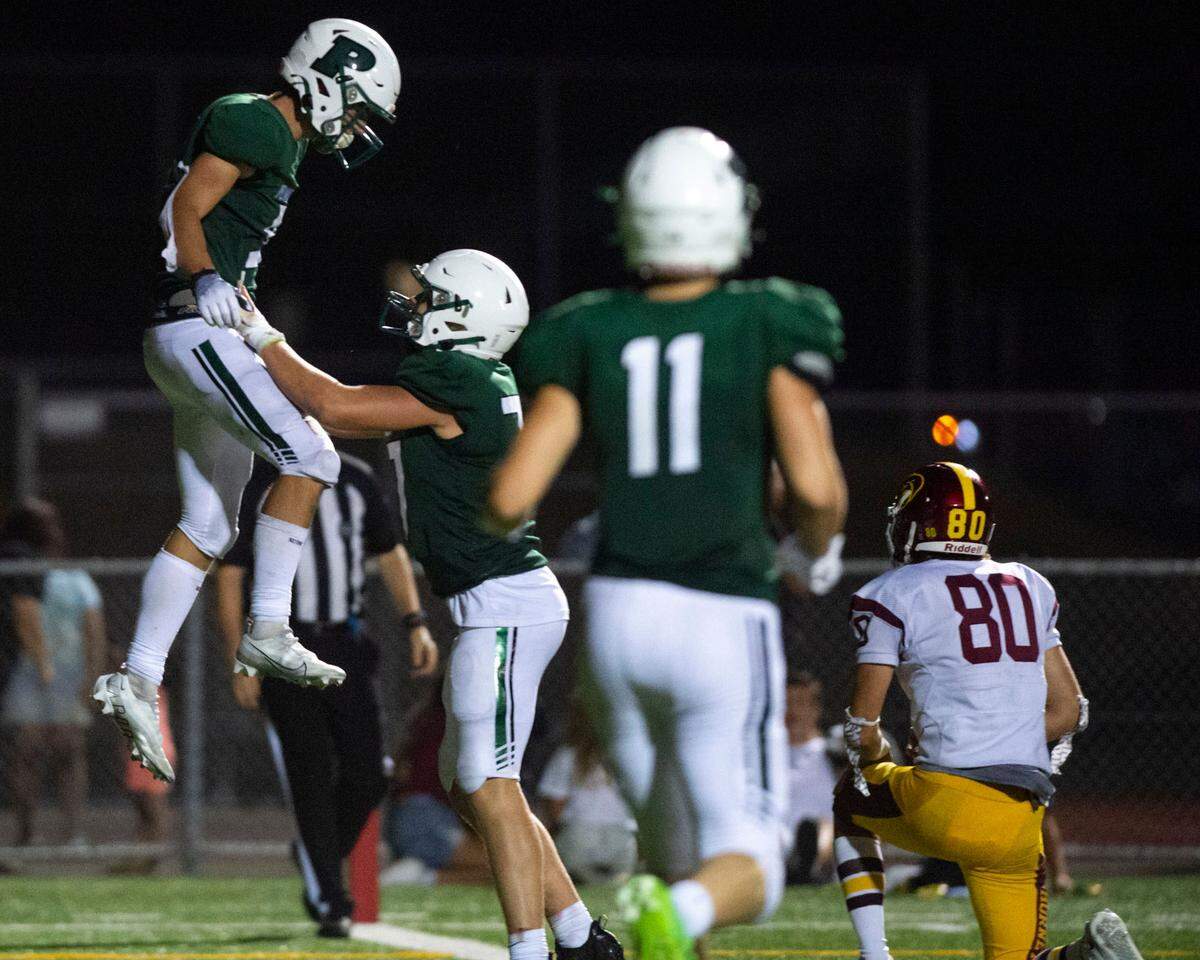 Peninsula receiver Dane Meddaugh is lifted up after catching a touchdown pass from quarterback Payton Knowles during the fourth quarter of a nonleague game against Enumclaw on Thursday, Sept. 1, 2022, at Roy Anderson Field in Gig Harbor Wash.